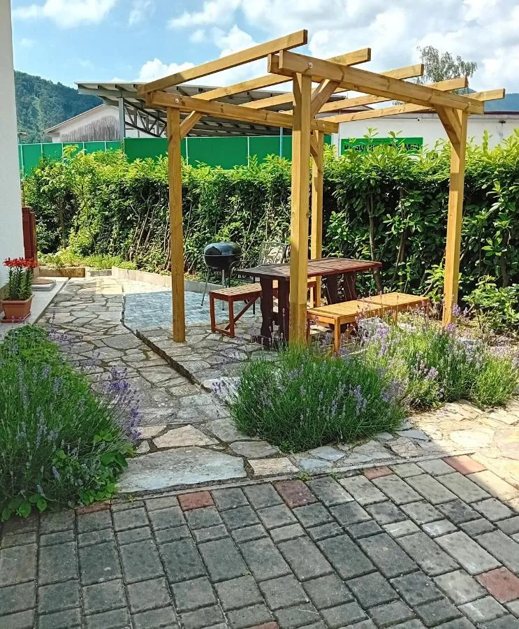 Lesena pergola z mizo in klopmi na vrtu ob apartmaju Maty